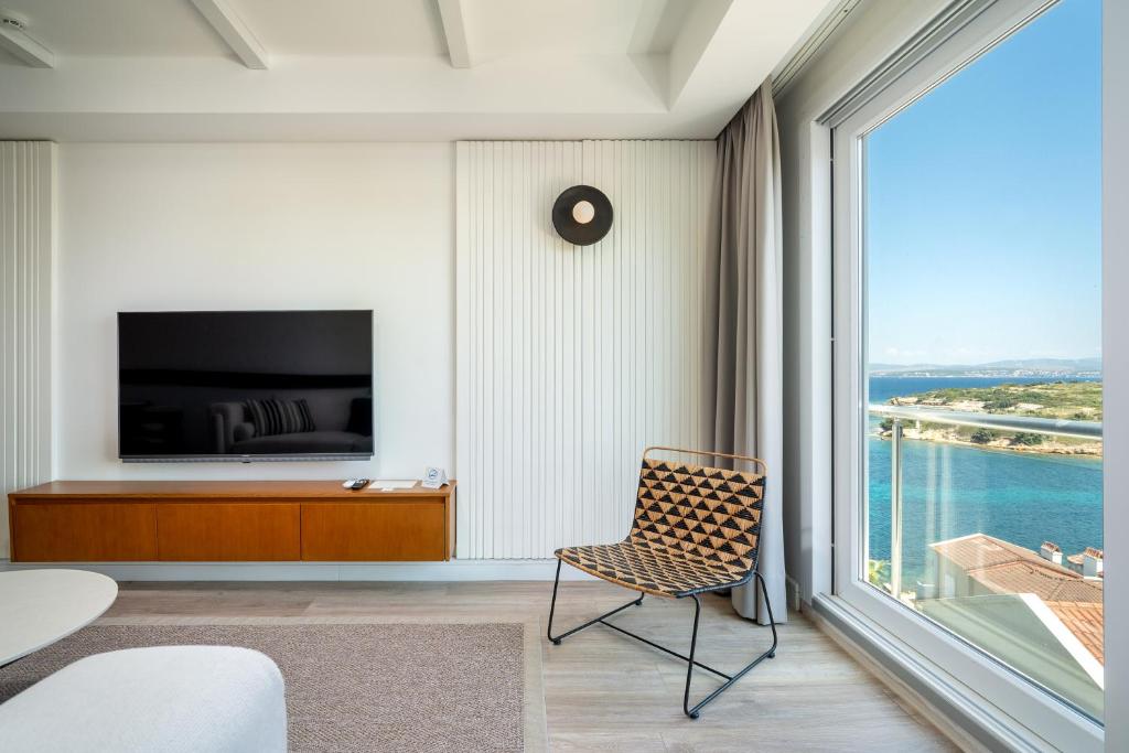 a room with a chair and a large window at Dalyan Residence & Suites in Cesme