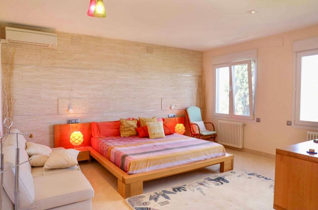 ein Schlafzimmer mit einem orangenen Bett und einem Sofa in der Unterkunft Villa Narby in Jávea