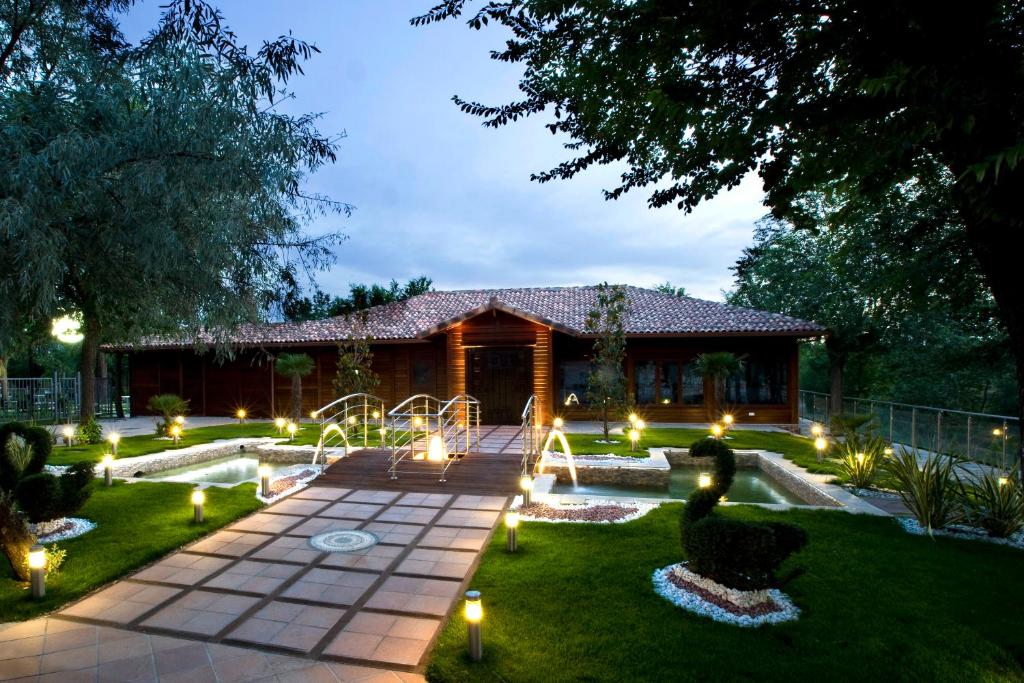 un jardín con luces frente a una casa en Complejo La Cigüeña en Arganda del Rey