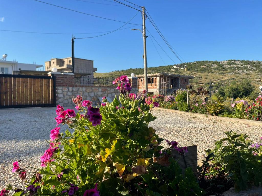 un giardino con fiori su una strada sterrata di Lake Side Serenity a Ksamil