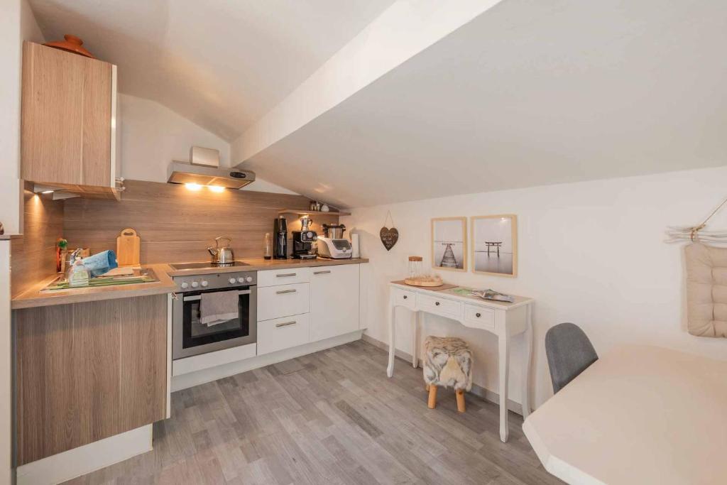 una cucina con mobili bianchi e un cane seduto al centro di Stubainest Schmidt Ferienwohnung a Fulpmes