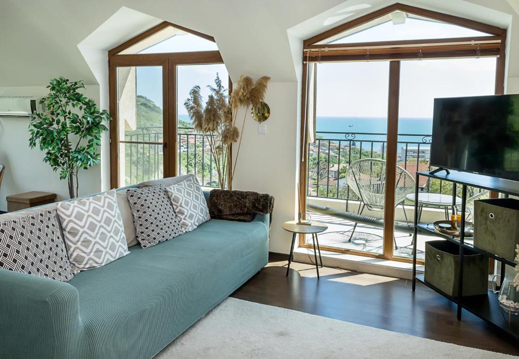 een woonkamer met een bank en een groot raam bij Panoramic Sea-View I 2-Bedroom Flat with Terrace by Flat Manаger in Balchik