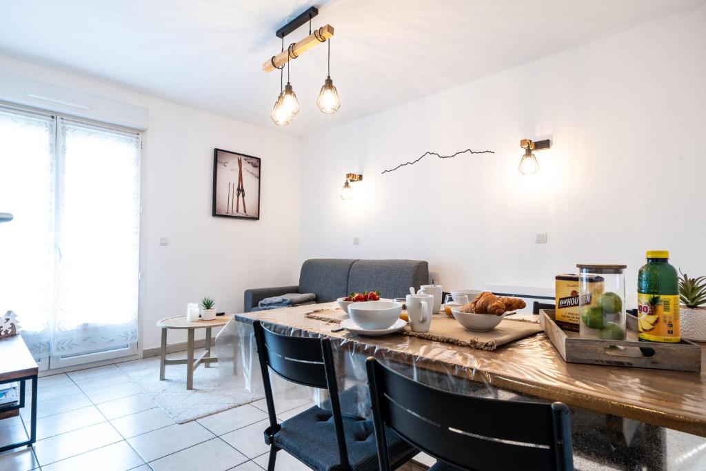 a kitchen and dining room with a table and chairs at Appartement cosy rue Pasteur in Briançon