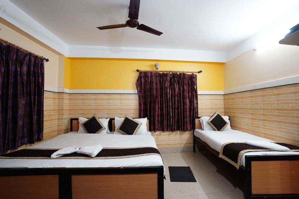Postel nebo postele na pokoji v ubytování Tirupati Lodge NJP