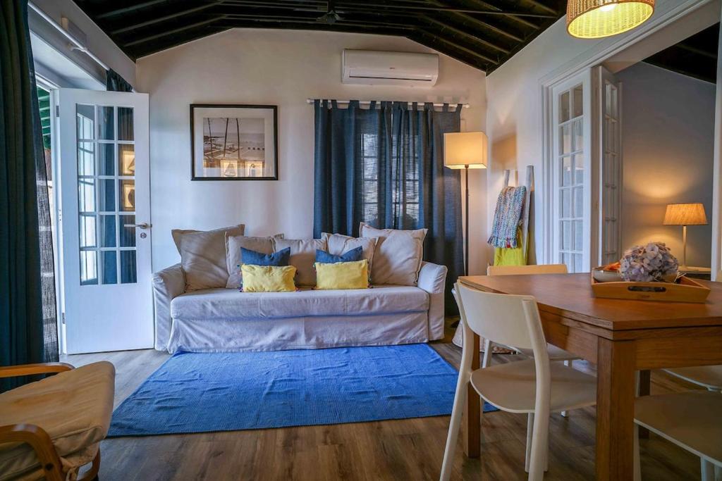 un soggiorno con un divano e un tavolo di GuestReady - OceanFront Lookout House a Ponta Delgada