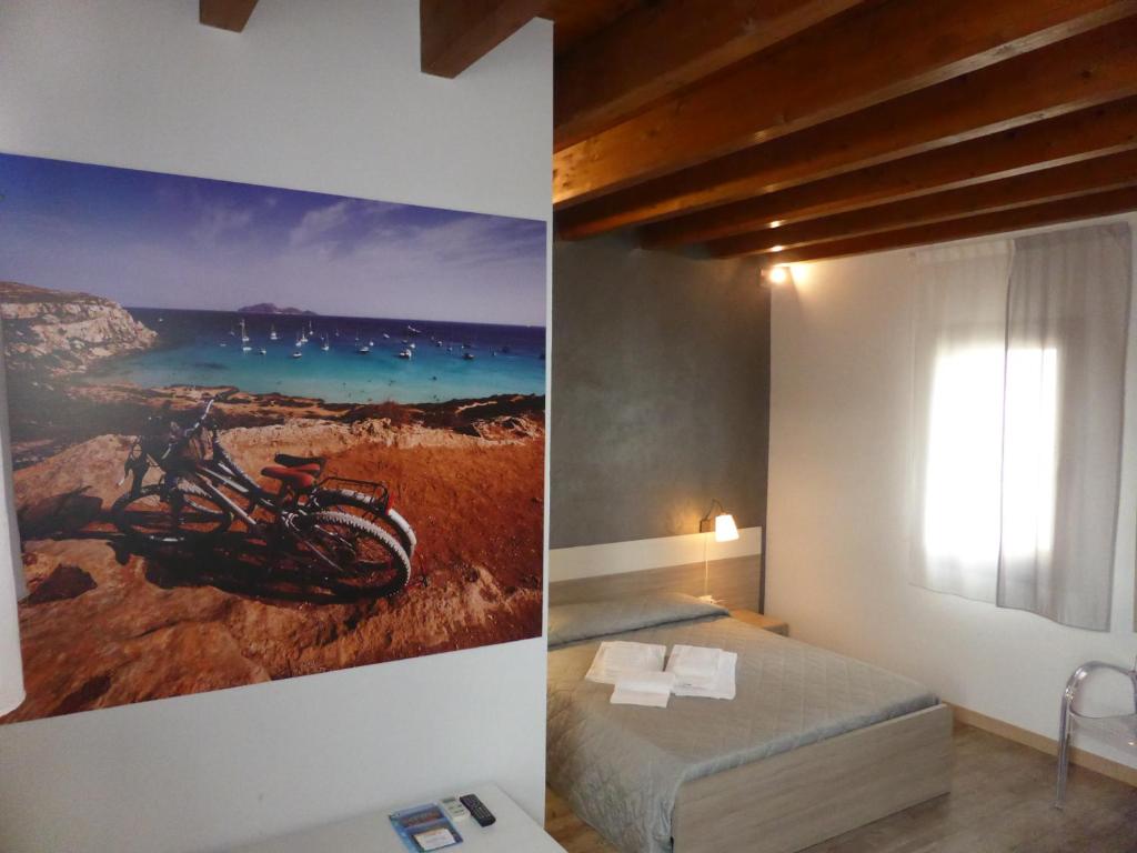 a bedroom with a painting of a motorcycle on the wall at Le Muse in Favignana