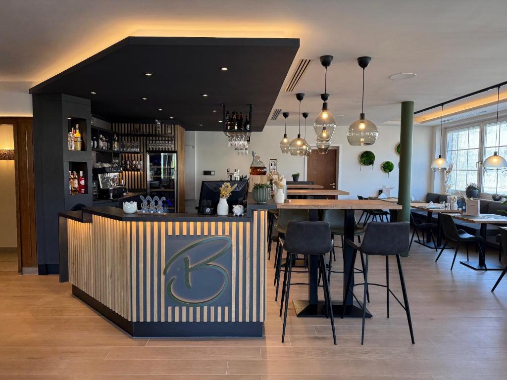 a restaurant with a bar with a table and chairs at Hotel Restaurant Brinckwirth in Ochtrup