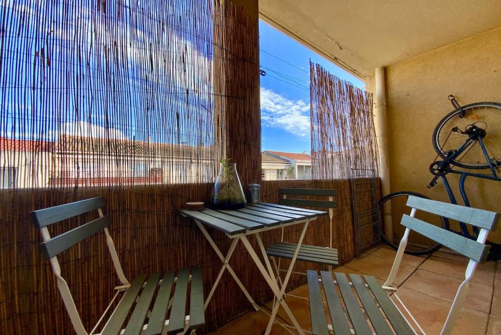 un balcon avec une table et deux chaises et une fenêtre dans l'établissement GROOMI Le Repos Du Lez - Proche rives du Lez, ensoleillé avec balcon !, à Montpellier