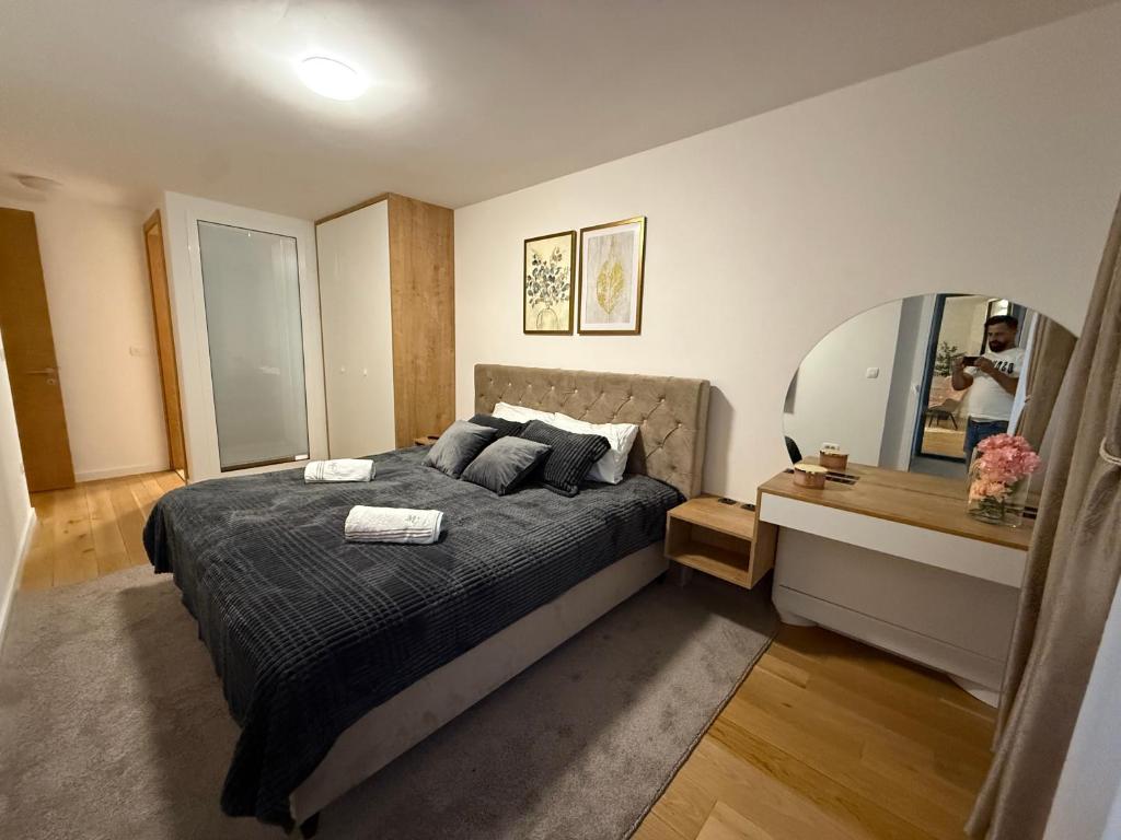 a bedroom with a large bed and a mirror at River Walk Sarajevo-Ilidza Best Apartman in Sarajevo