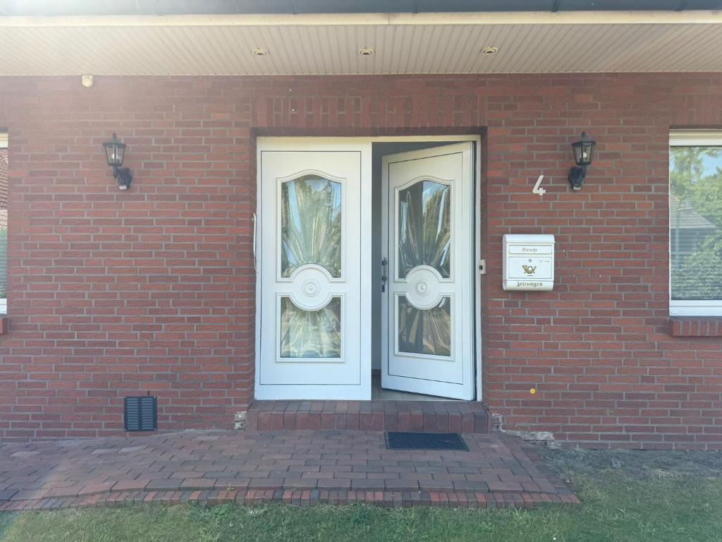 a brick house with two white doors on it at LlVINQ 11 in Emstek