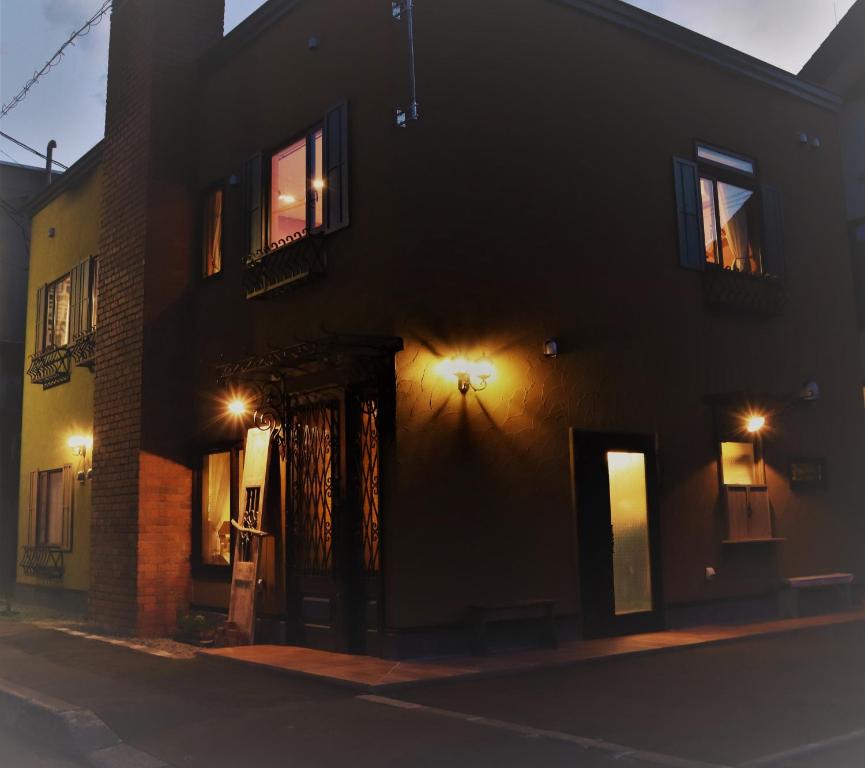 a building with a door on a street at night at Hotel Unica in Biei