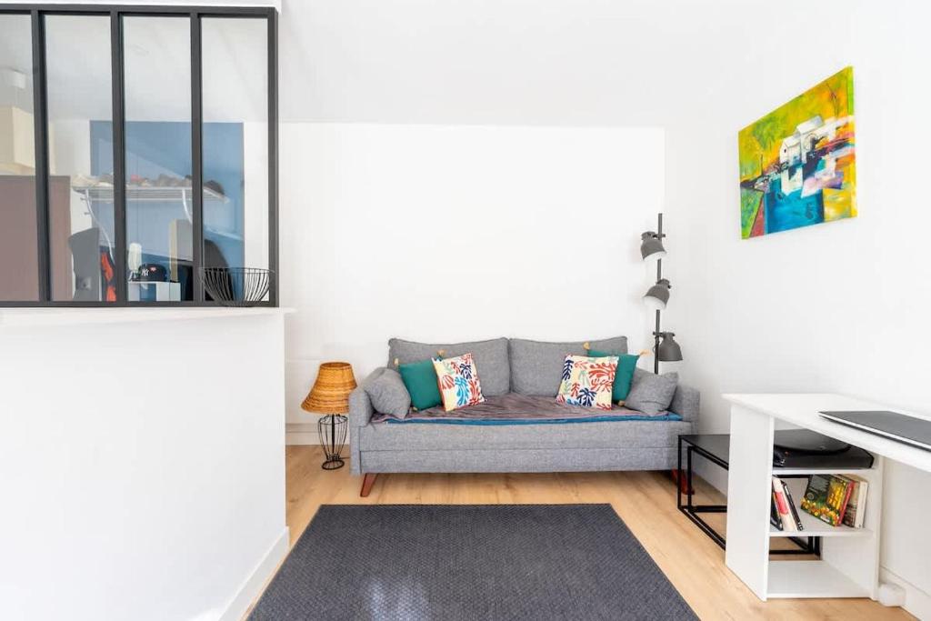 un salon avec un canapé et une table dans l'établissement Appartement Ville en bois, à La Rochelle