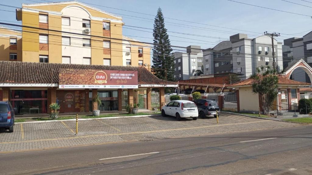 una strada con auto parcheggiate davanti agli edifici di Apartamento Novo, Lindo e Confortável prox Centro a Gravataí