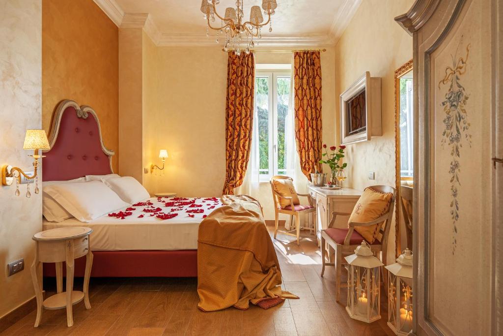 1 dormitorio con 1 cama, mesa y sillas en Relais Empire, en Verona