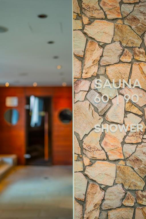 two pictures of a lobby with a stone wall at Don Giovanni Hotel Prague - Great Hotels of The World in Prague