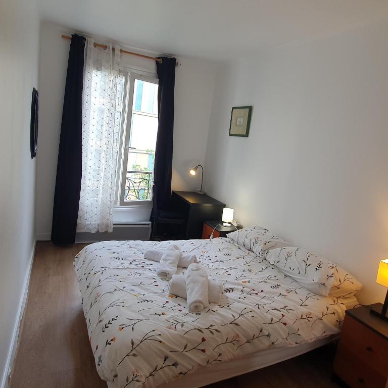 une chambre avec un lit avec des serviettes dessus dans l'établissement Appartement au cœur de Paris, à Paris