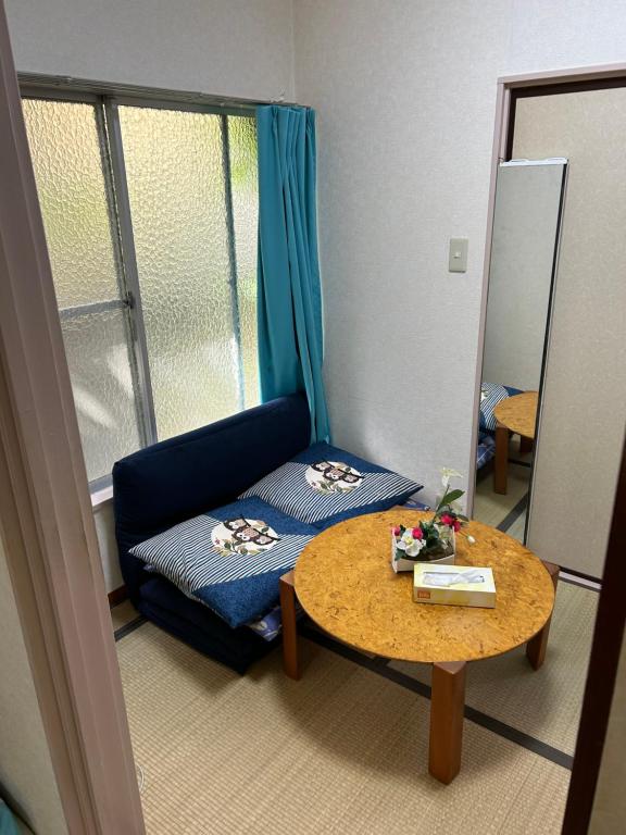 ein Wohnzimmer mit einer Couch und einem Tisch in der Unterkunft ハイツドリーム梦想小屋 in Tokio