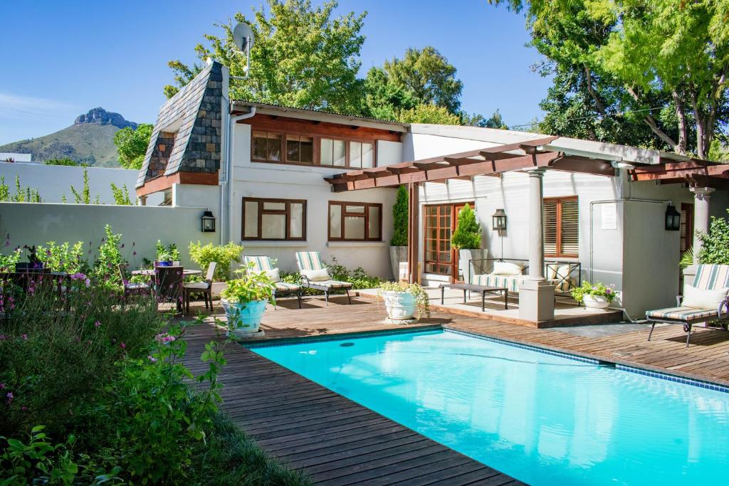 a backyard with a swimming pool and a house at 5 Seasons Guest House in Stellenbosch