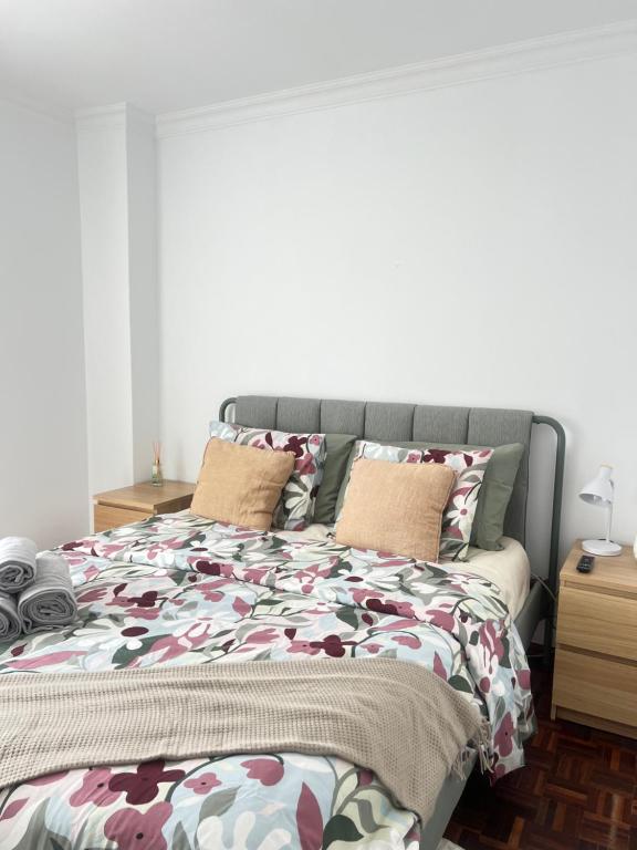 a bedroom with a large bed with floral sheets at Pink House - Lisbon in Lisbon