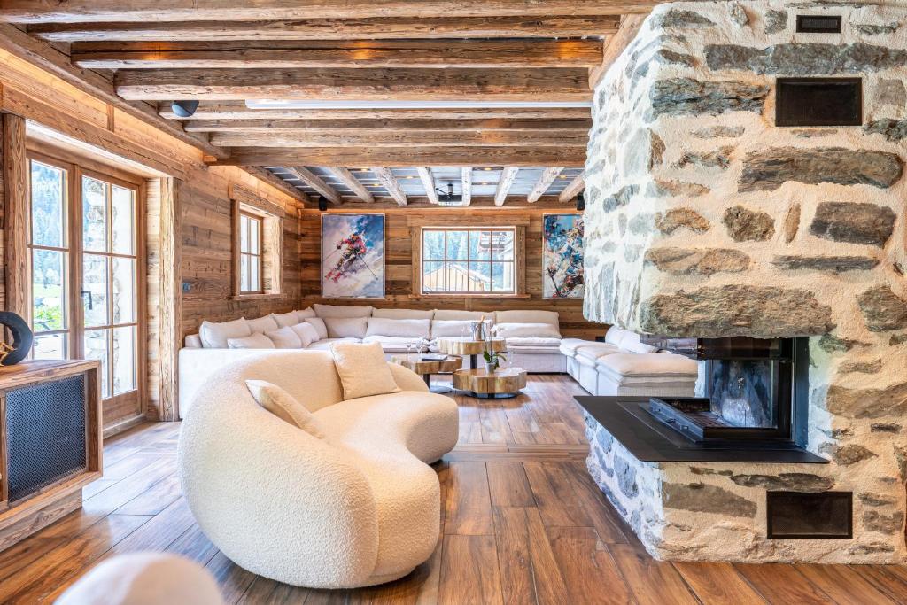 a living room with a stone fireplace at Chalet Gaston in Champagny-en-Vanoise