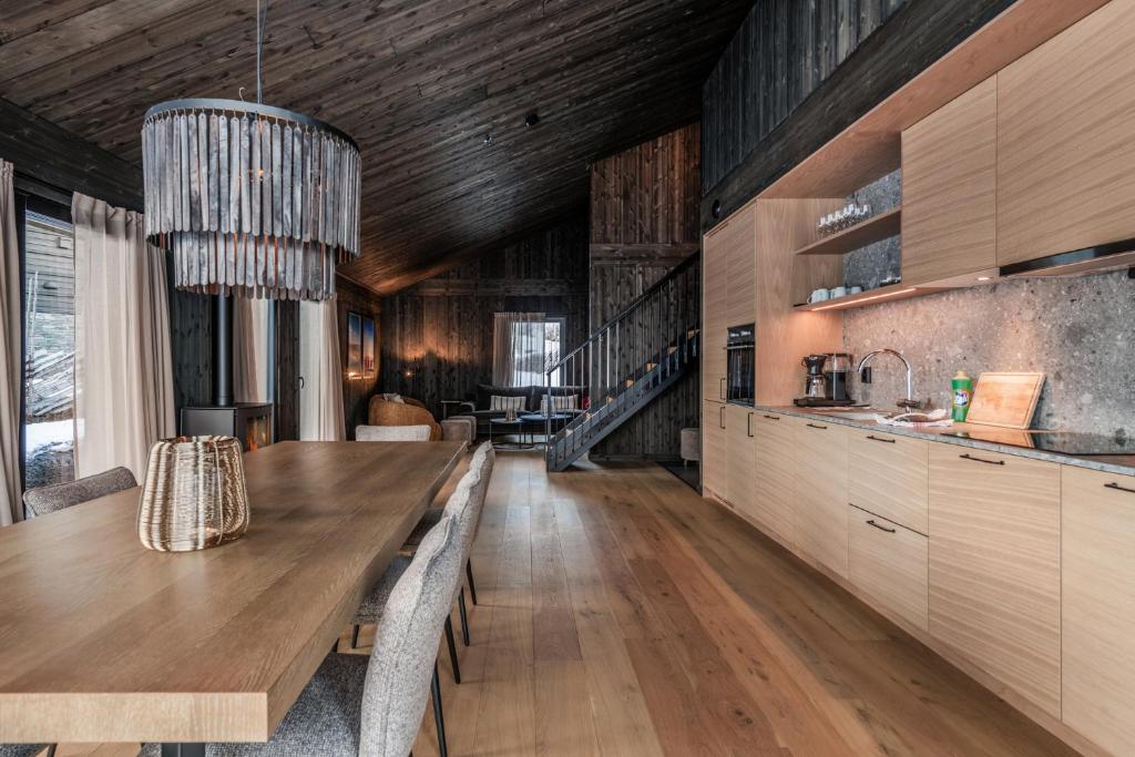 a kitchen with a wooden ceiling and a dining table at Kikut Alpin Lodge 1301 in Hol