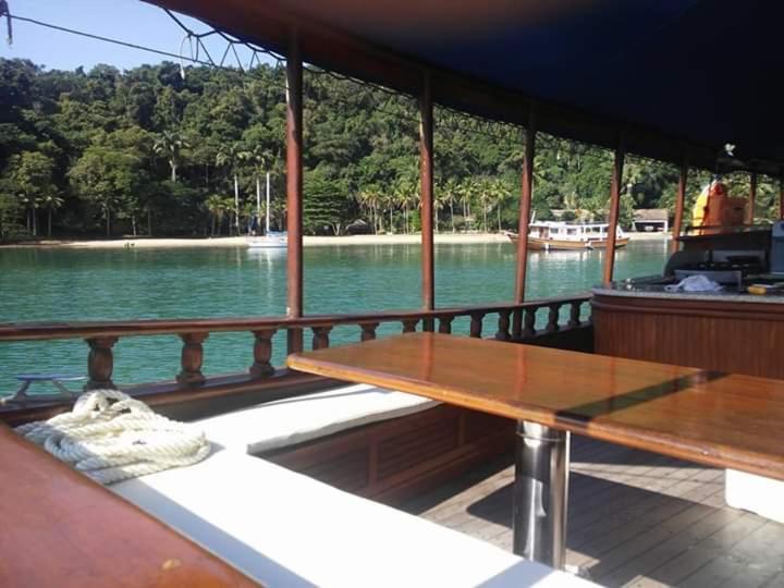 una mesa de madera en la parte trasera de un barco en Passeio de barco na Escuna Ibiza, en Paraty