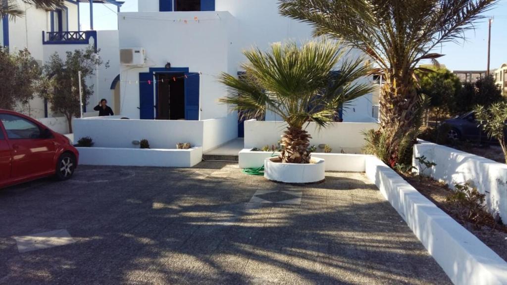 a parking lot with palm trees and a white building at Cycladic Relaxation Corner in Fira