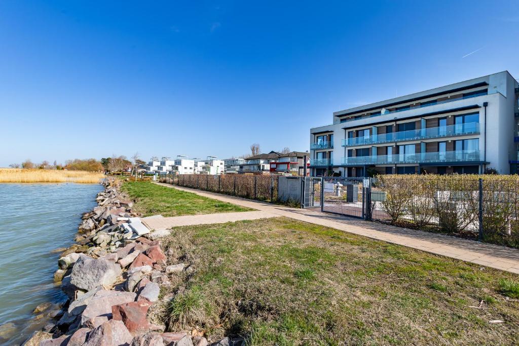 ein Gebäude neben einem Gewässer in der Unterkunft Sunset Resort 409 With Pool - Happy Rentals in Fonyód