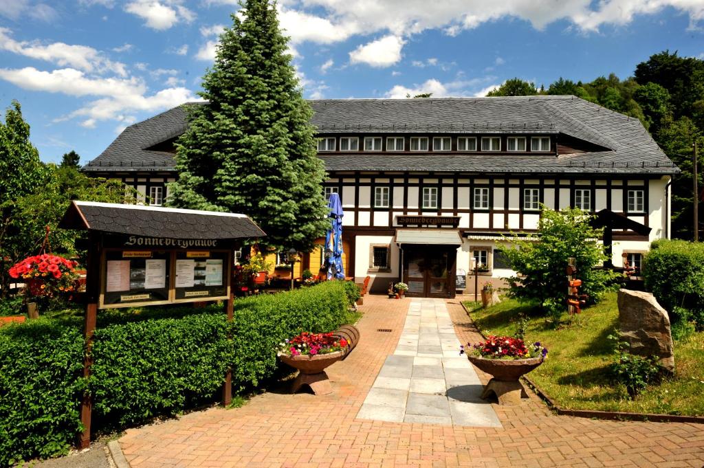 um grande edifício preto e branco com uma árvore em Wanderhotel Sonnebergbaude em Waltersdorf