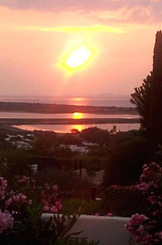 un coucher de soleil sur un plan d'eau avec le soleil couchant dans l'établissement Mas de O, à Saint Pierre La Mer