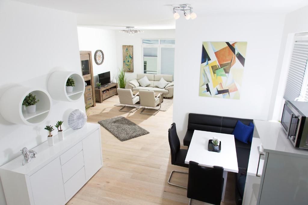 een woonkamer met witte meubels en een eetkamer bij Ferienwohnung Wilma in Ostseebad Sellin
