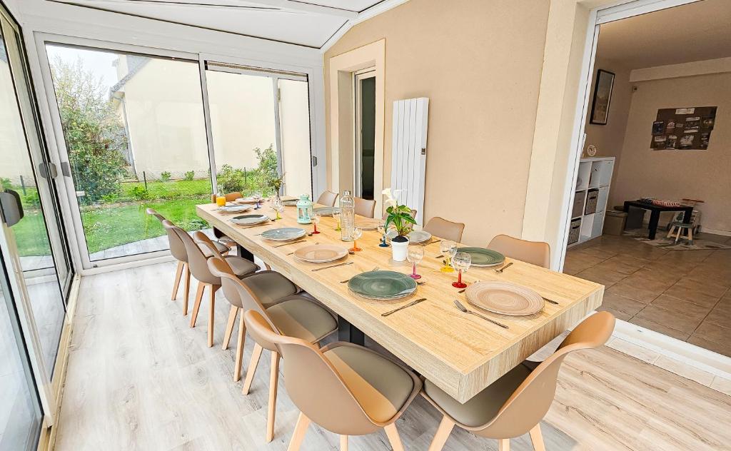 une grande salle à manger avec une longue table et des chaises dans l'établissement Cousinades and XXL family, terrace, à Merville-Franceville-Plage