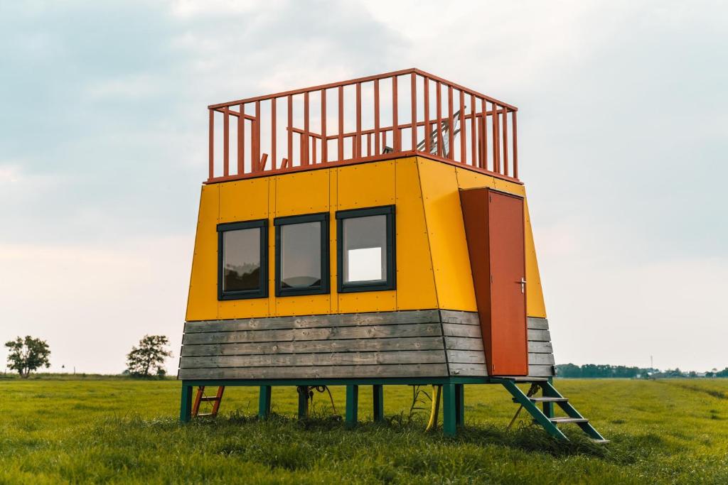 a small house sitting in the middle of a field at Hihahut De Zonnepost in Oud-Ade