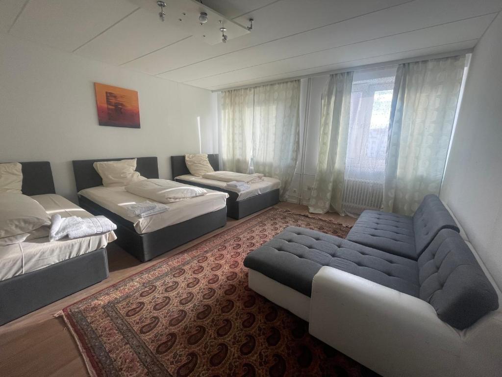 ハノーファーにあるCity Group Apartmentのベッド2台とソファのあるリビングルーム