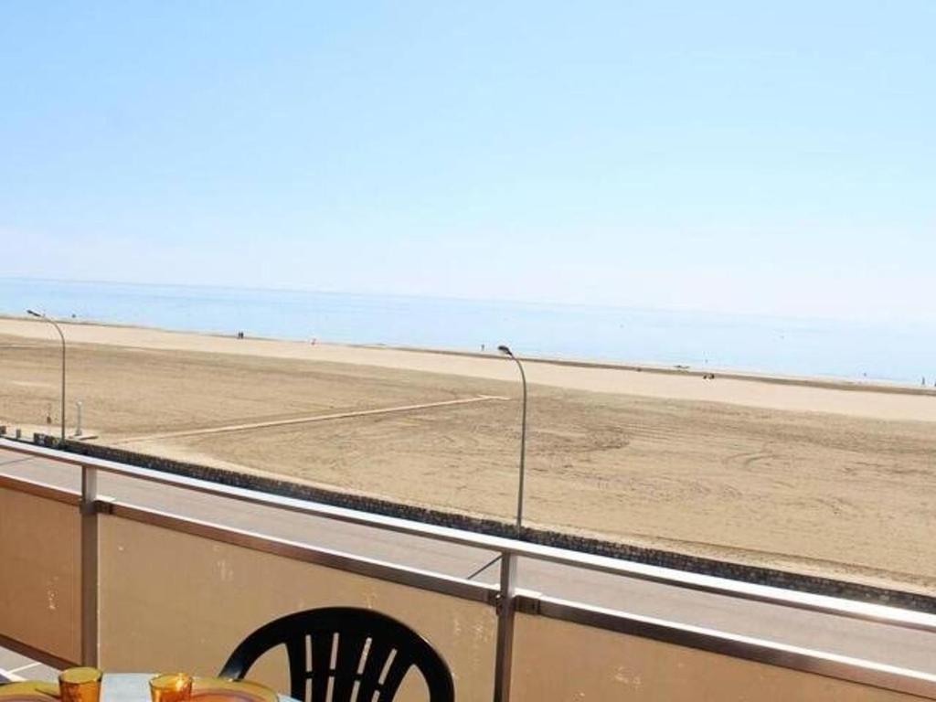 une table et des chaises sur un balcon donnant sur la plage dans l'établissement Appartement 3 pièces avec parking, à 10m de la plage - 6 couchages - FR-1-229C-171, à Port-la-Nouvelle