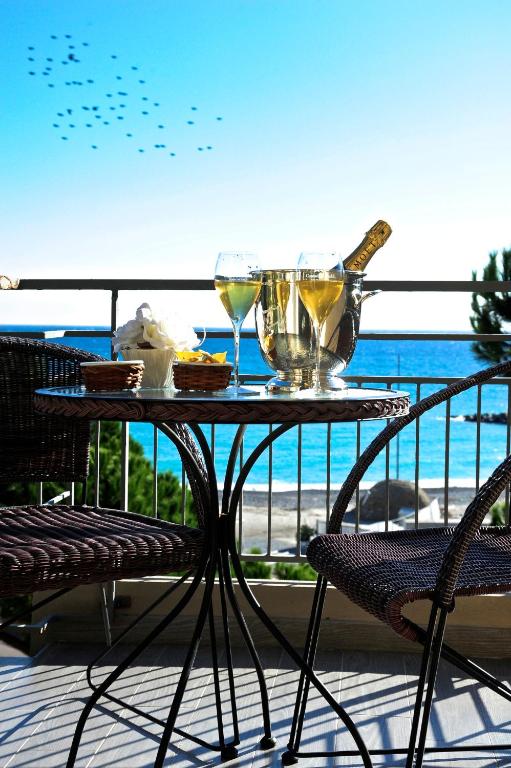 a table with two glasses of wine on a balcony at Sole Mare in Ventimiglia