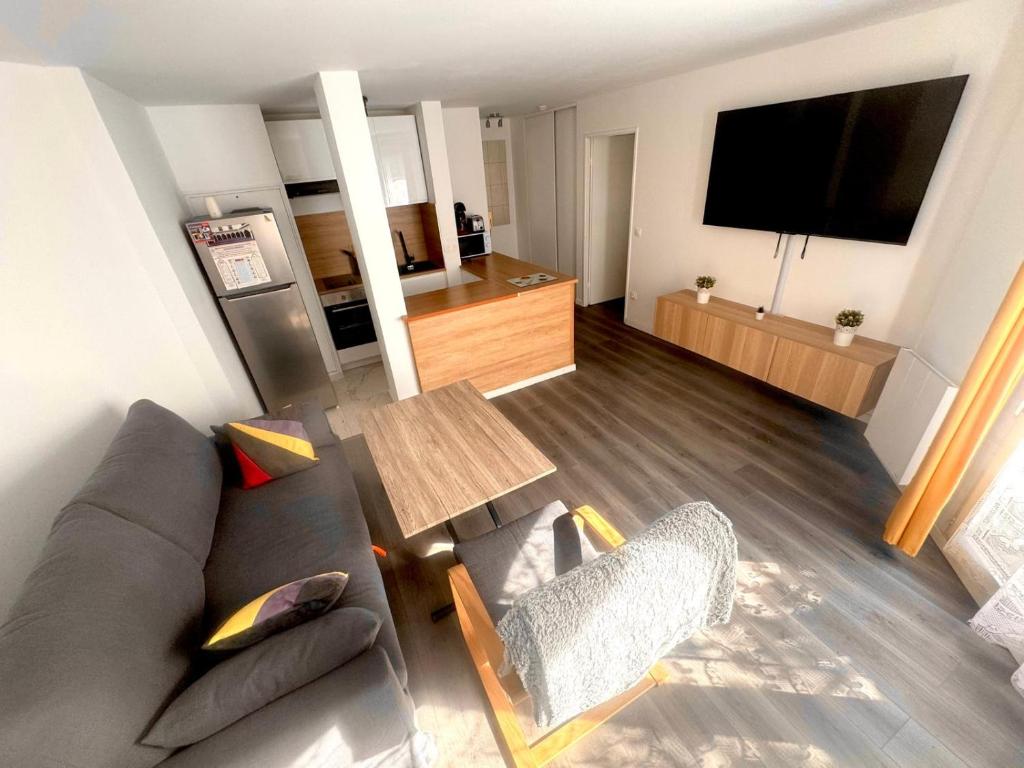 a living room with a couch and a table at 24 7 Open Apartment Parking 15'Paris 5'Athletica bis in Saint-Gratien