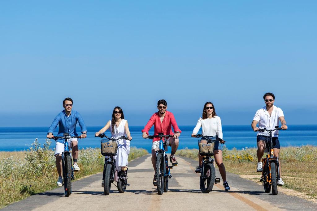 a group of people riding bikes on the beach at Case Vacanza Loria in Castelluzzo