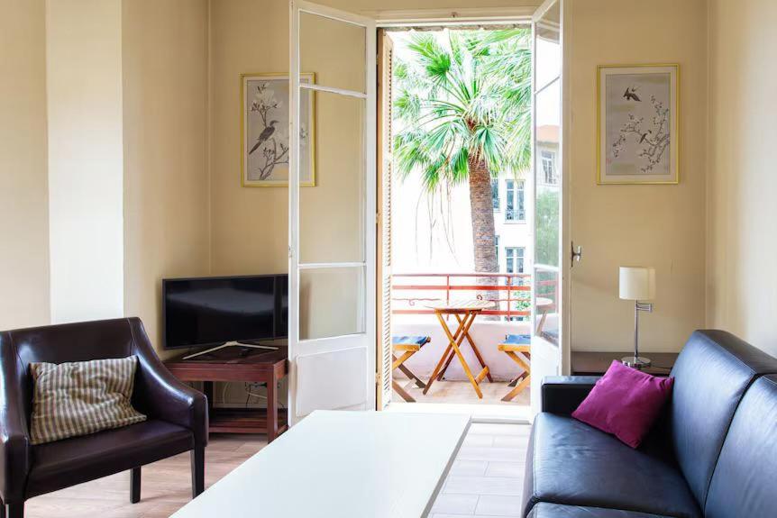 une chambre avec un lit, un canapé et une télévision dans l'établissement Charmant appartement avec terrasse en plein cœur de Nice à deux pas de la mer !, à Nice