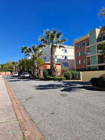 une rue vide avec des palmiers et un bâtiment dans l'établissement Villa Florentine Fréjus, à Fréjus