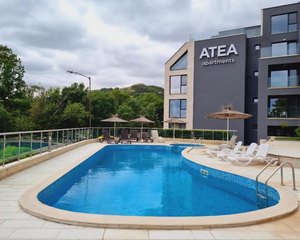 a swimming pool in front of a building at ATEA PERLA apartments in Kavarna