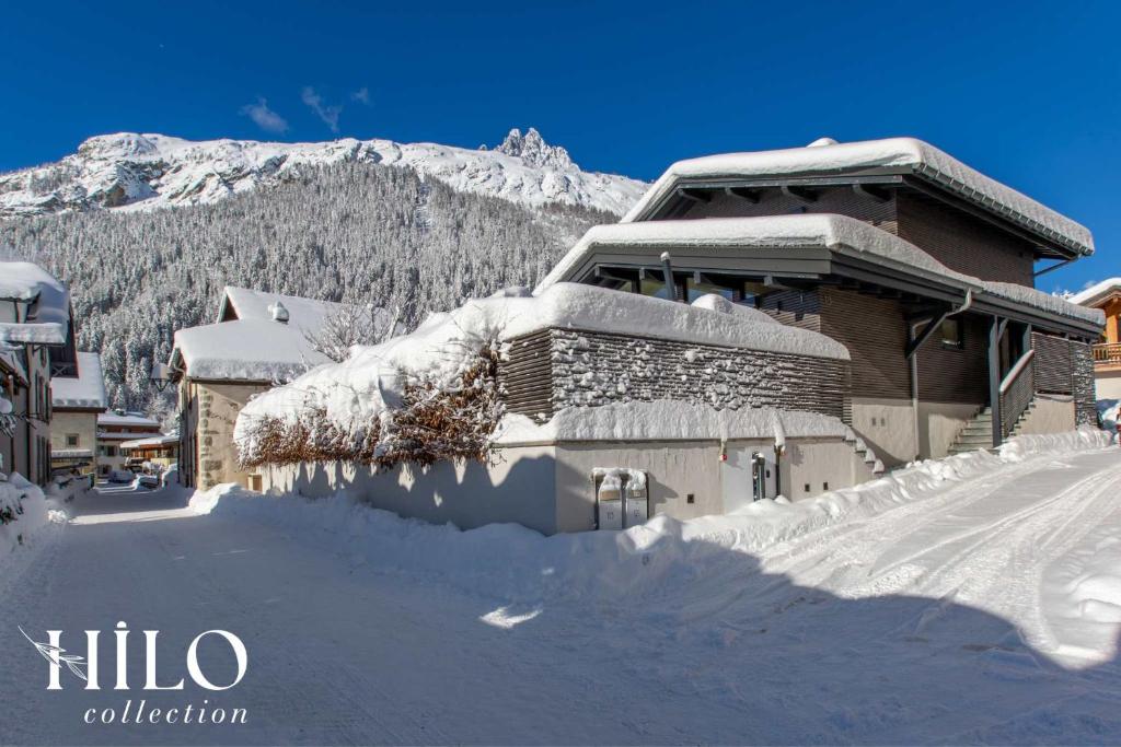 une maison recouverte de neige avec une montagne en arrière-plan dans l'établissement A great chalet for 4 people with Jacuzzi, à Chamonix-Mont-Blanc