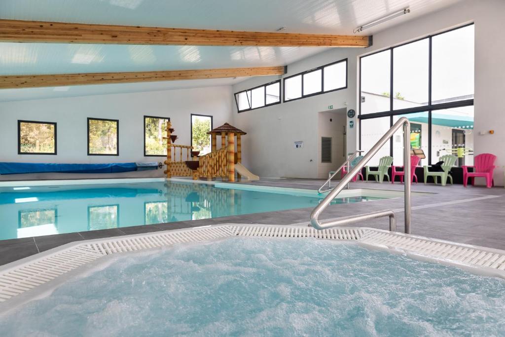 une grande piscine avec un pool house avec fenêtres dans l'établissement Mobil home 2 chambres à 800m de la mer, à Saint-Hilaire-de-Riez