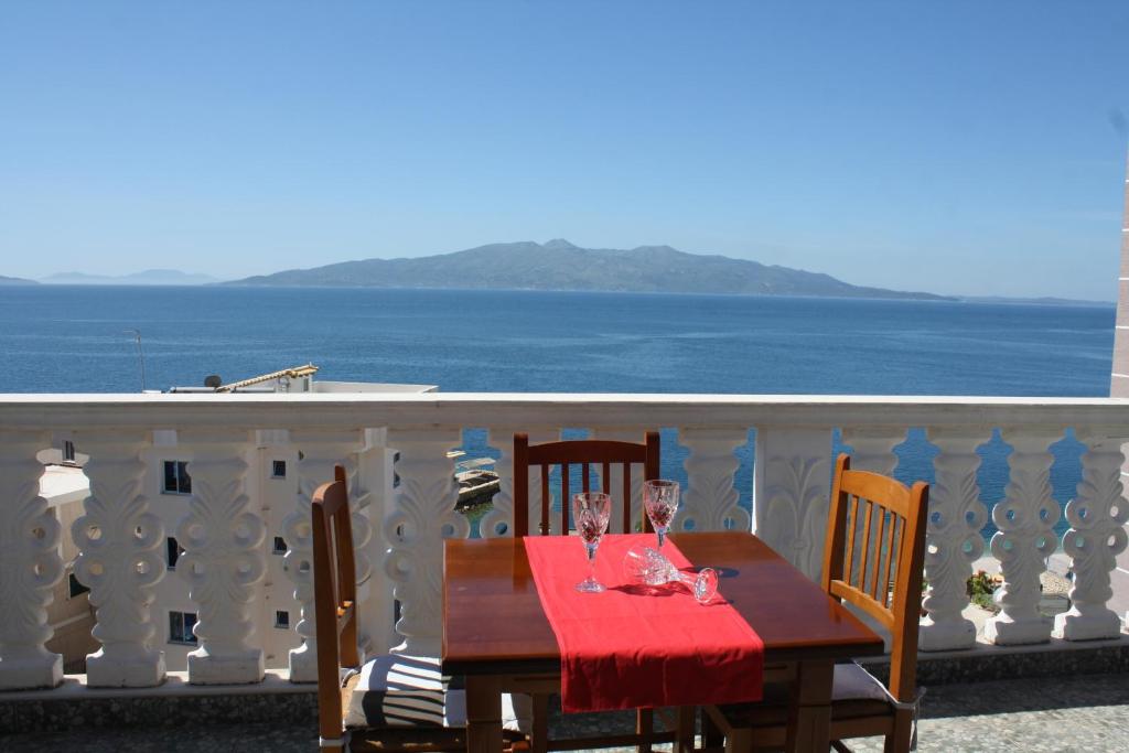 una mesa en un balcón con vistas al océano en Villa Mucho, en Sarandë