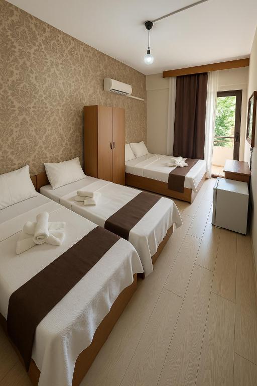 a hotel room with two beds and a window at Panorama Hotel Özdere in Ortaköy