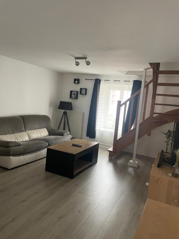 un salon avec un canapé et une table basse dans l'établissement Duplex cosy, à Vesoul