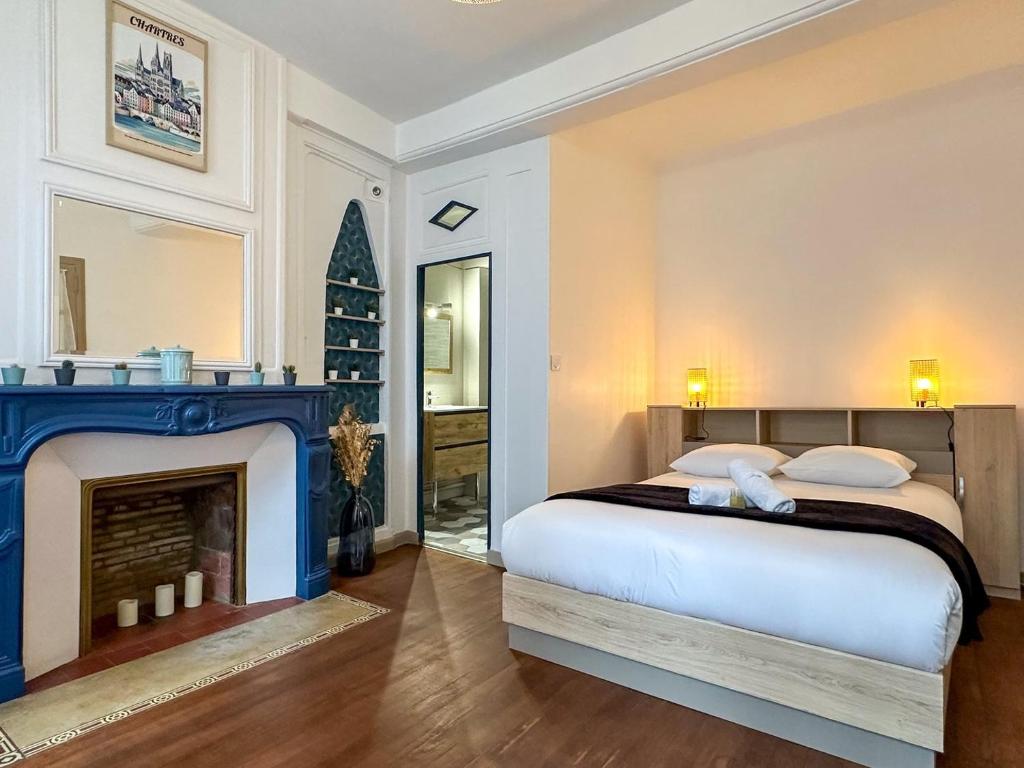 une chambre avec un lit et une cheminée dans l'établissement Le Foyer Chartrain, à Chartres
