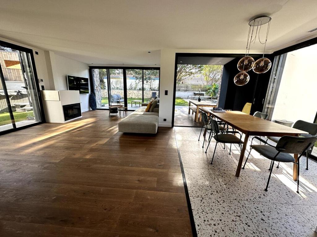 a living room with a table and a dining room at Maison bord de mer Anglet in Anglet