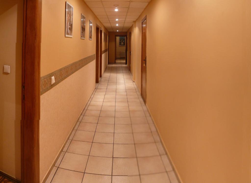 a long hallway with a tile floor in a building at nakvinės namai Mano kelias in Vilnius