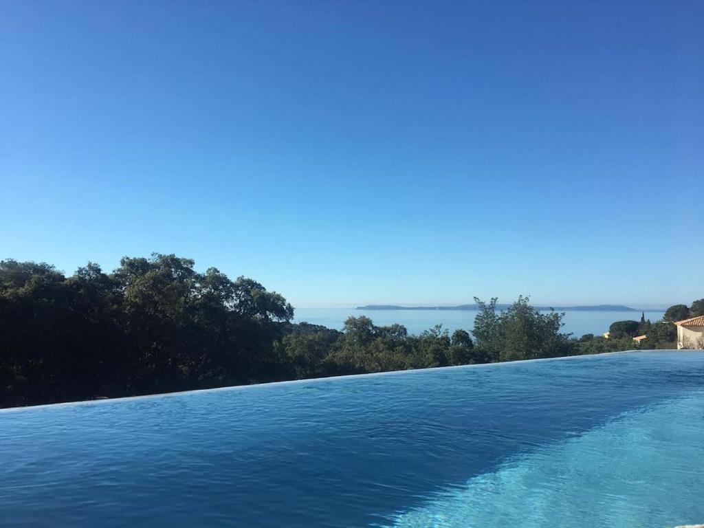 une piscine avec vue sur l'eau dans l'établissement Villa des Savoyards, à Rayol-Canadel-sur-Mer